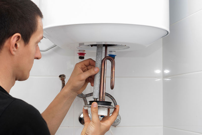 Plombier chauffagiste effectuant l'entretien d'une chaudière à gaz